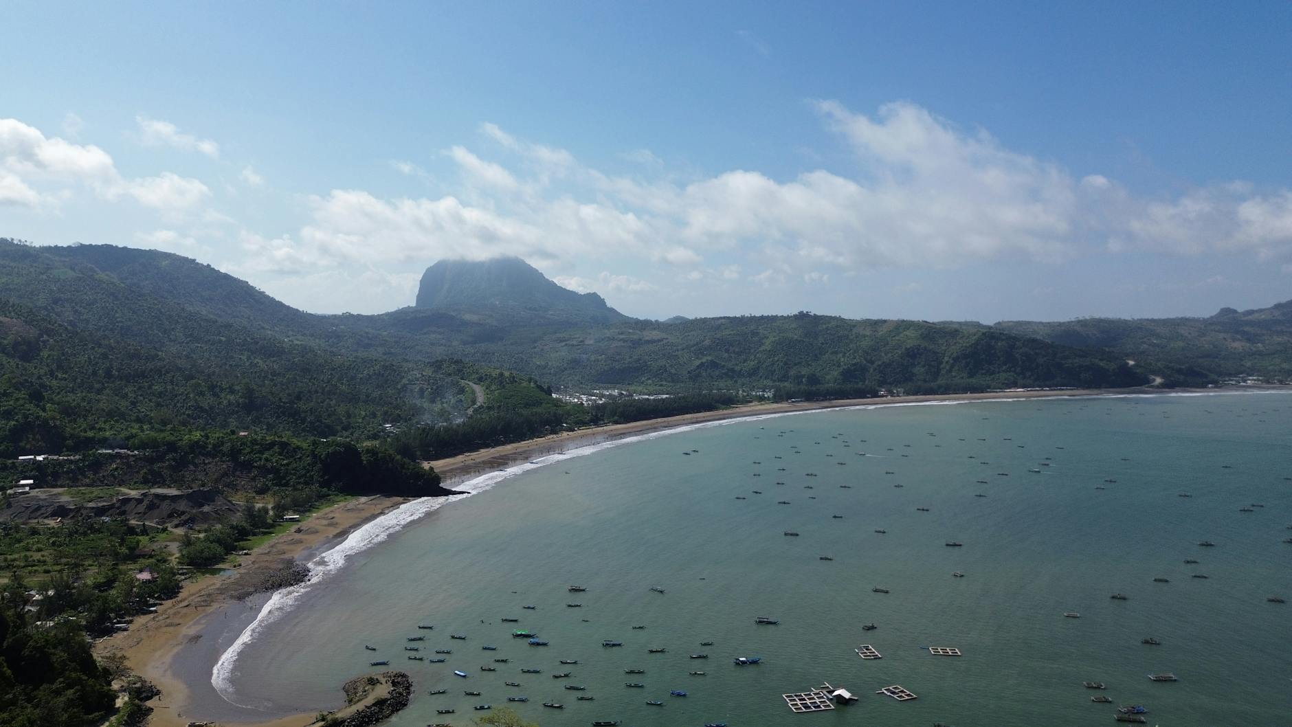 Indonezyjska plaża u stóp porośniętej zielenią góry z lotu ptaka