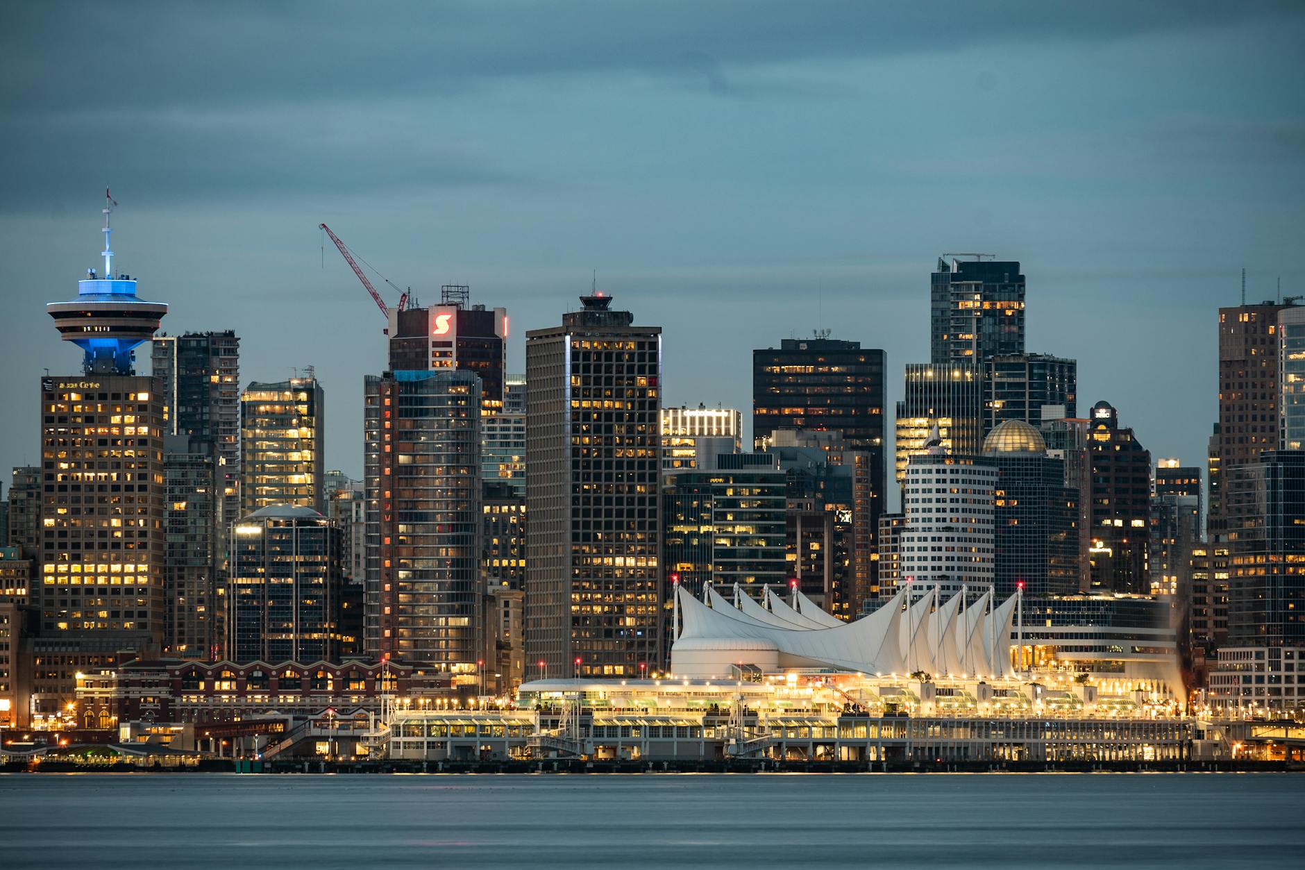 Wieczorny skyline Vancouver z Canada Place odbijającym światła miasta