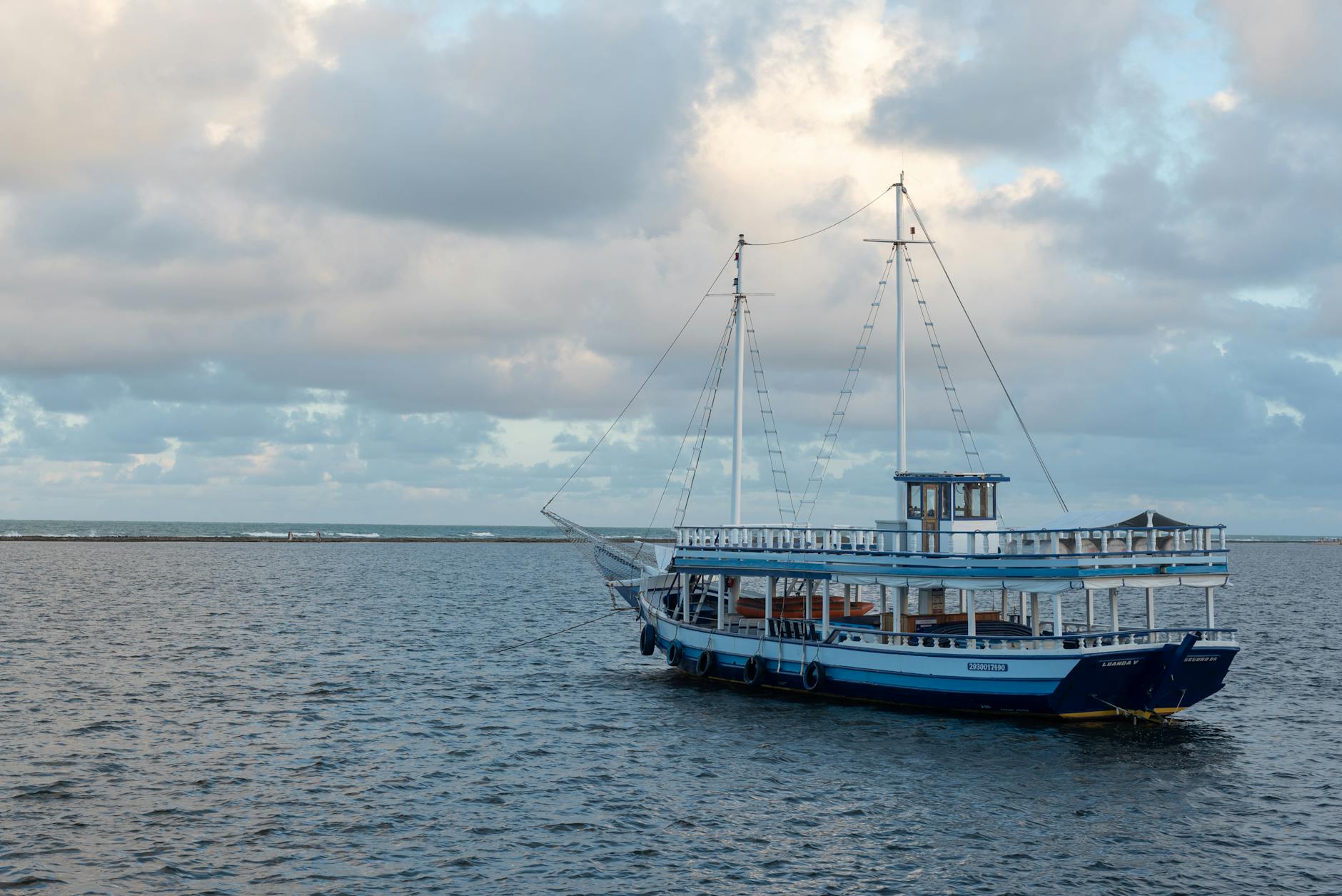 Łódź na spokojnej wodzie w Arraial d'Ajuda w Brazylii pod pochmurnym niebem