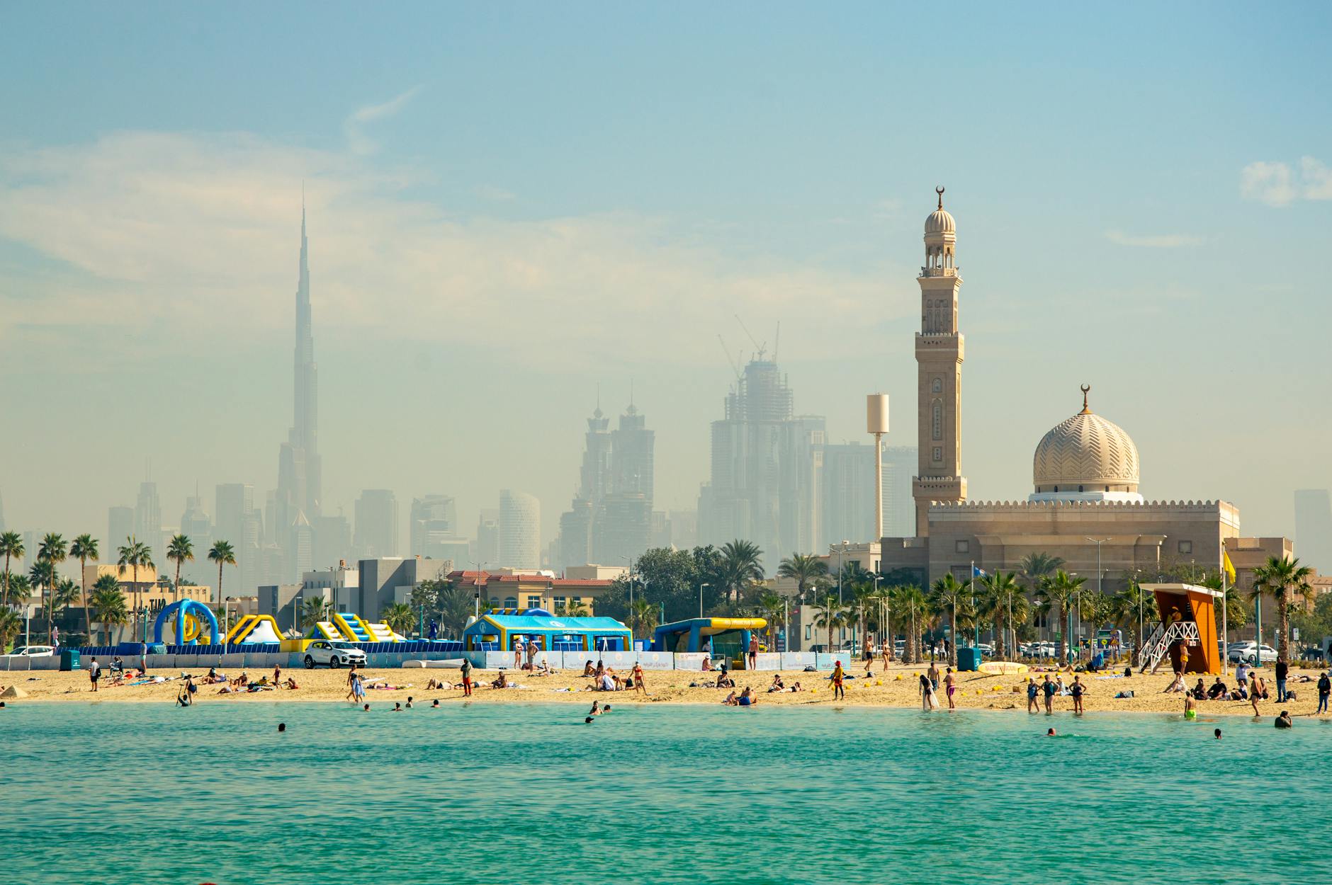 Dubaj z dziećmi: atrakcje, plaże i praktyczne wskazówki dla rodzin Rodzinna plaża w Dubaju z panoramą miasta, Burdż Chalifą i meczetem